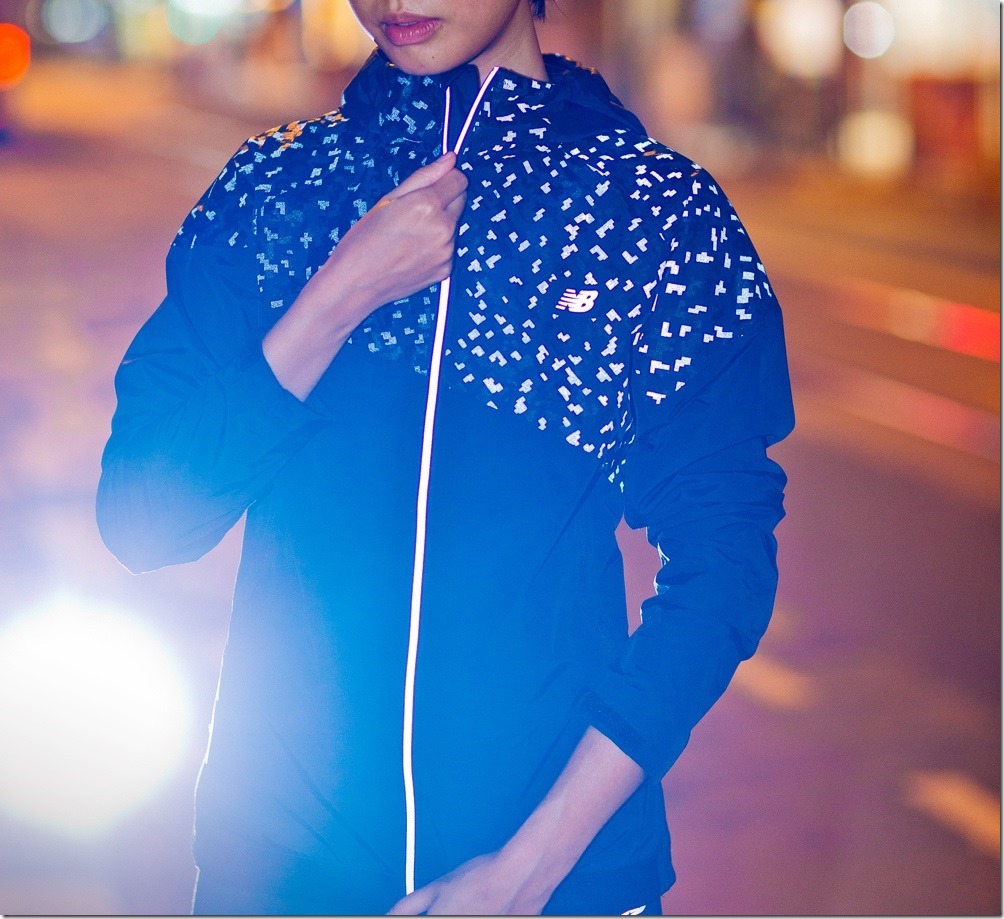 New Balance反光印花連帽風衣外套除布面反光圖樣外，更運用於連帽與拉鍊上，不只時尚同時加強夜間運動安全，專為秋冬氣候設計的防潑水材質，無論遇風遇雨都能夠盡情享受慢跑樂趣