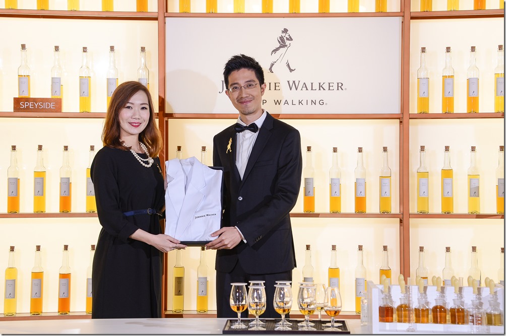 2_JOHNNIE WALKER調和實驗室開幕帝亞吉歐資深行銷協理楊雅婷(左)致贈調和實驗袍予莊東杰指揮(右)