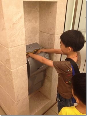 孩童洗手後，使用dyson_airblade乾手機快速乾手，預防流感