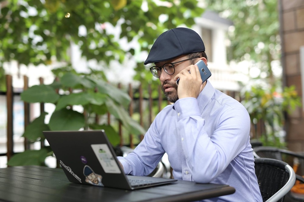 圖像裡可能有一或多人、大家坐著、電話、帽子、筆記型電腦和戶外