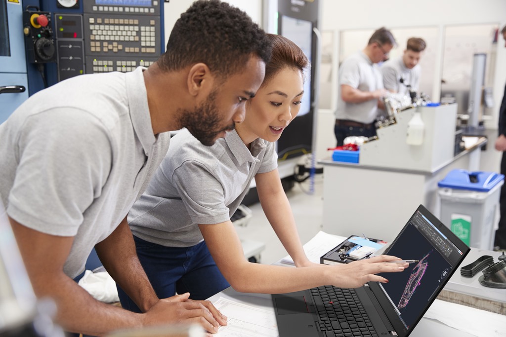 Two Engineers Using CAD Programming Software On Laptop